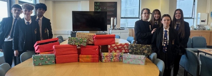Students from St Luke's stood around a table with thier filled shoeboxes